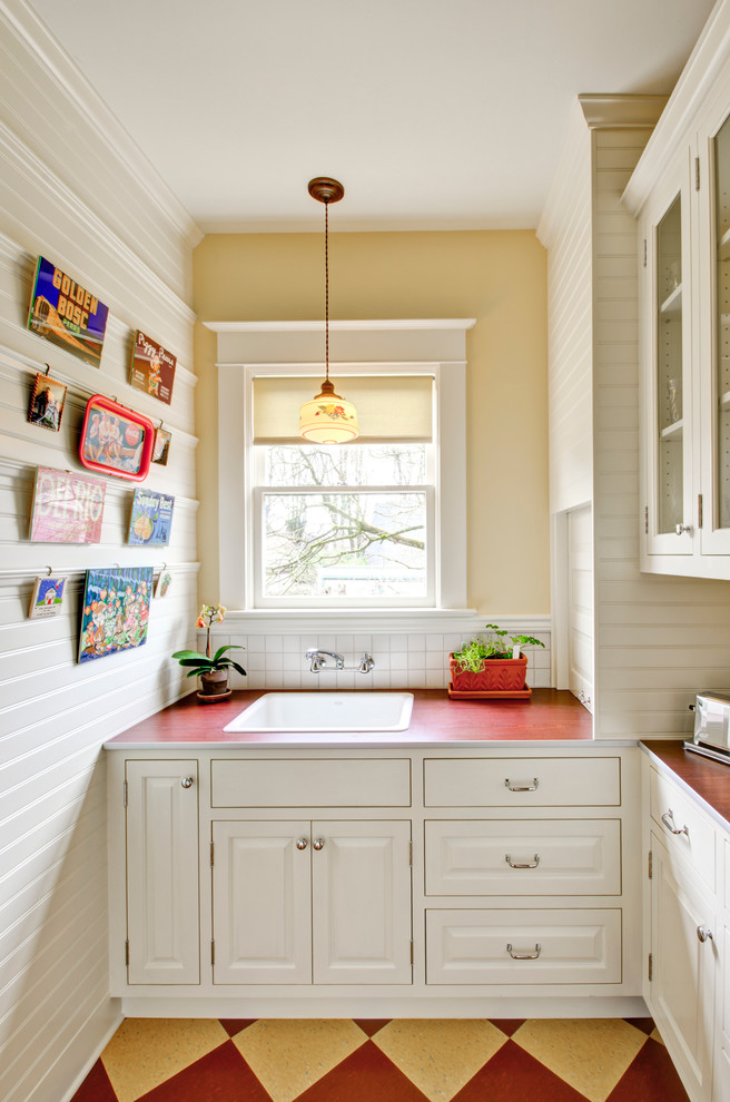 Inspiration for a timeless enclosed kitchen remodel in Portland with raised-panel cabinets, white cabinets, laminate countertops, white backsplash and a drop-in sink
