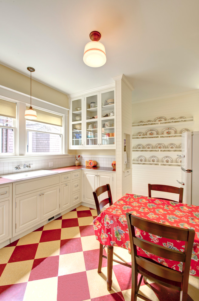 Modelo de cocina tradicional con fregadero encastrado, armarios tipo vitrina, puertas de armario blancas, encimera de laminado y electrodomésticos blancos