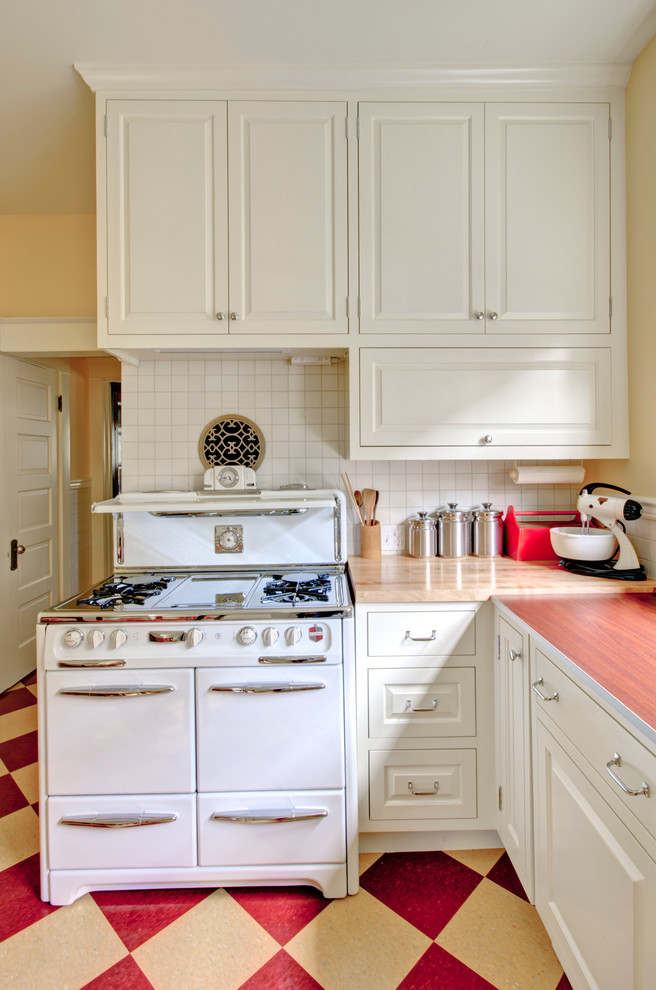 Country kitchen photo in Portland with raised-panel cabinets, white cabinets, laminate countertops, white backsplash and white appliances