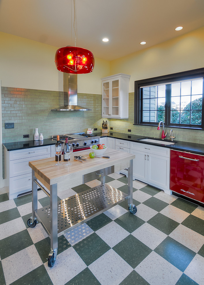 Foto di una cucina moderna di medie dimensioni con lavello sottopiano, ante in stile shaker, ante bianche, paraspruzzi verde, elettrodomestici colorati e pavimento in linoleum