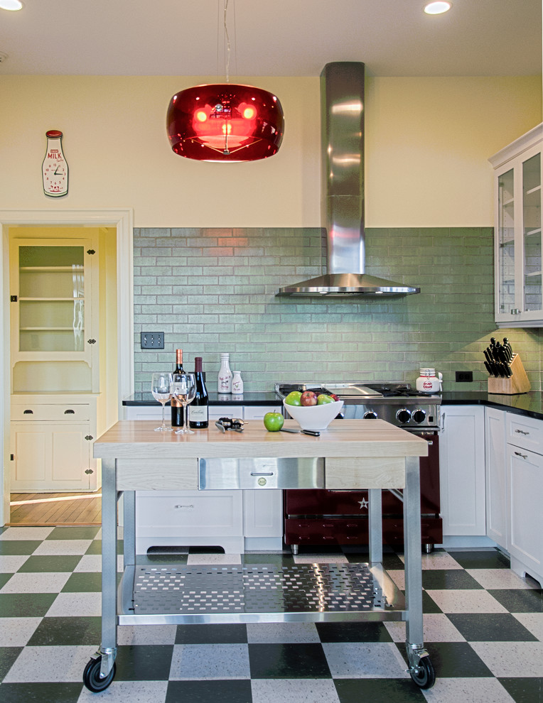 На фото: угловая кухня среднего размера в стиле ретро с обеденным столом, врезной мойкой, фасадами в стиле шейкер, белыми фасадами, зеленым фартуком, цветной техникой, полом из линолеума и островом