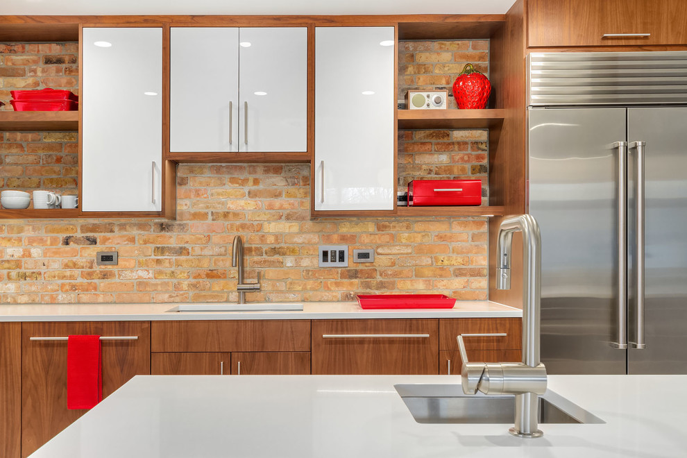 Photo of a medium sized midcentury l-shaped kitchen/diner in Chicago with a submerged sink, flat-panel cabinets, white cabinets, engineered stone countertops, brown splashback, brick splashback, stainless steel appliances, terrazzo flooring, an island and beige floors.