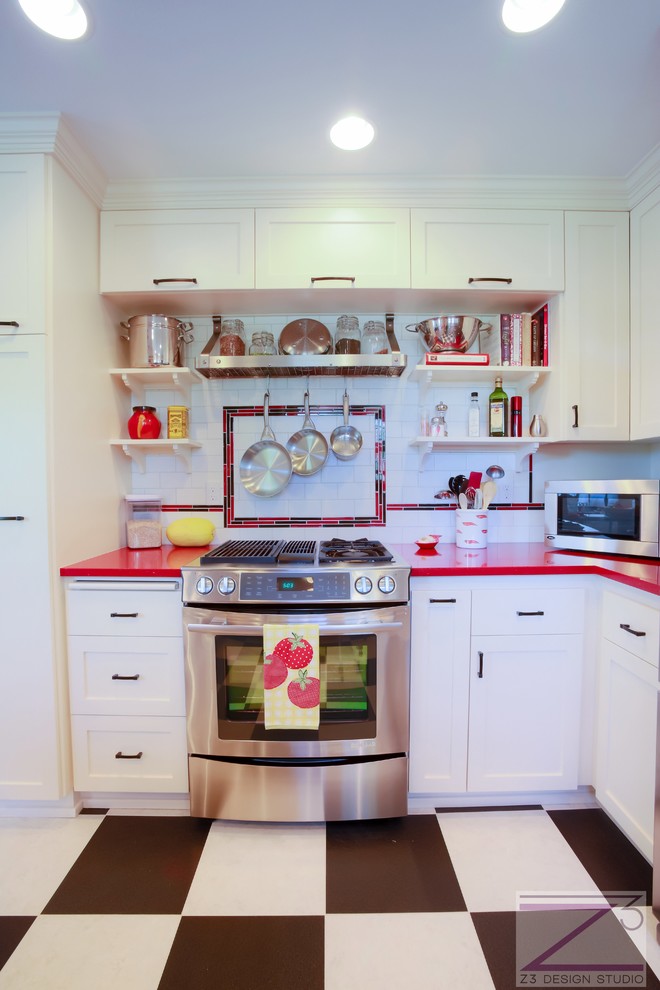 Inredning av ett eklektiskt litet u-kök, med en undermonterad diskho, skåp i shakerstil, vita skåp, bänkskiva i kvarts, vitt stänkskydd, stänkskydd i tunnelbanekakel, rostfria vitvaror, klinkergolv i keramik och en halv köksö