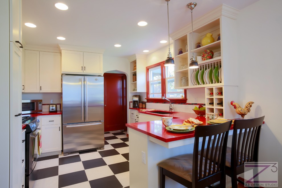Inspiration for a small eclectic u-shaped ceramic tile kitchen remodel in Charleston with an undermount sink, shaker cabinets, white cabinets, quartz countertops, white backsplash, subway tile backsplash, stainless steel appliances and a peninsula
