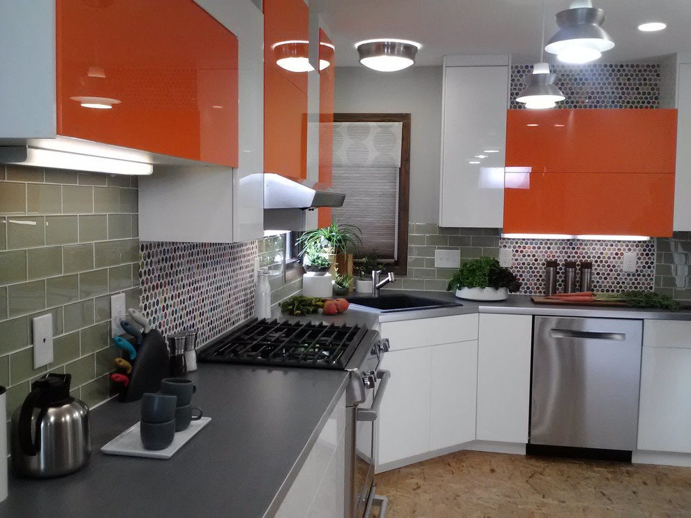 Inredning av ett eklektiskt mellanstort kök, med en enkel diskho, släta luckor, orange skåp, laminatbänkskiva, grönt stänkskydd, stänkskydd i tunnelbanekakel, rostfria vitvaror och plywoodgolv
