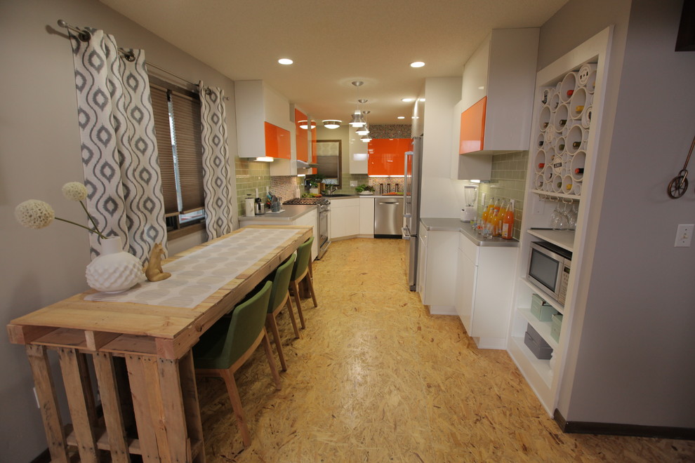 Eklektisk inredning av ett mellanstort kök, med en enkel diskho, släta luckor, orange skåp, laminatbänkskiva, grönt stänkskydd, stänkskydd i tunnelbanekakel, rostfria vitvaror och plywoodgolv
