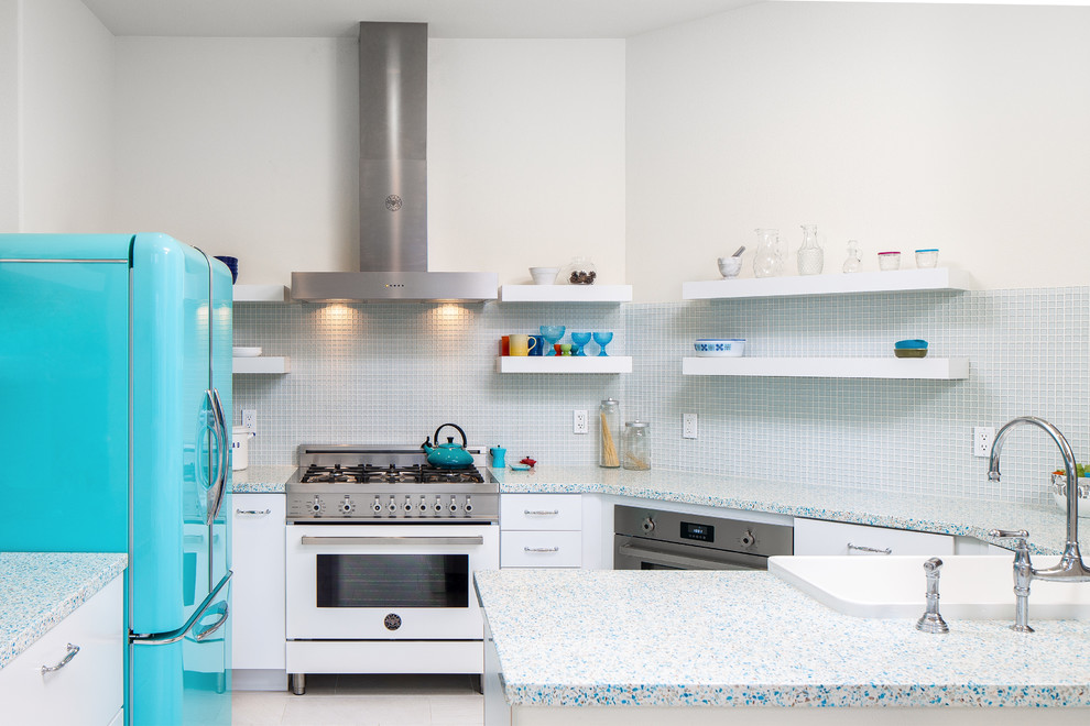 Example of a small eclectic u-shaped porcelain tile eat-in kitchen design in San Francisco with a farmhouse sink, flat-panel cabinets, white cabinets, recycled glass countertops, blue backsplash and glass sheet backsplash