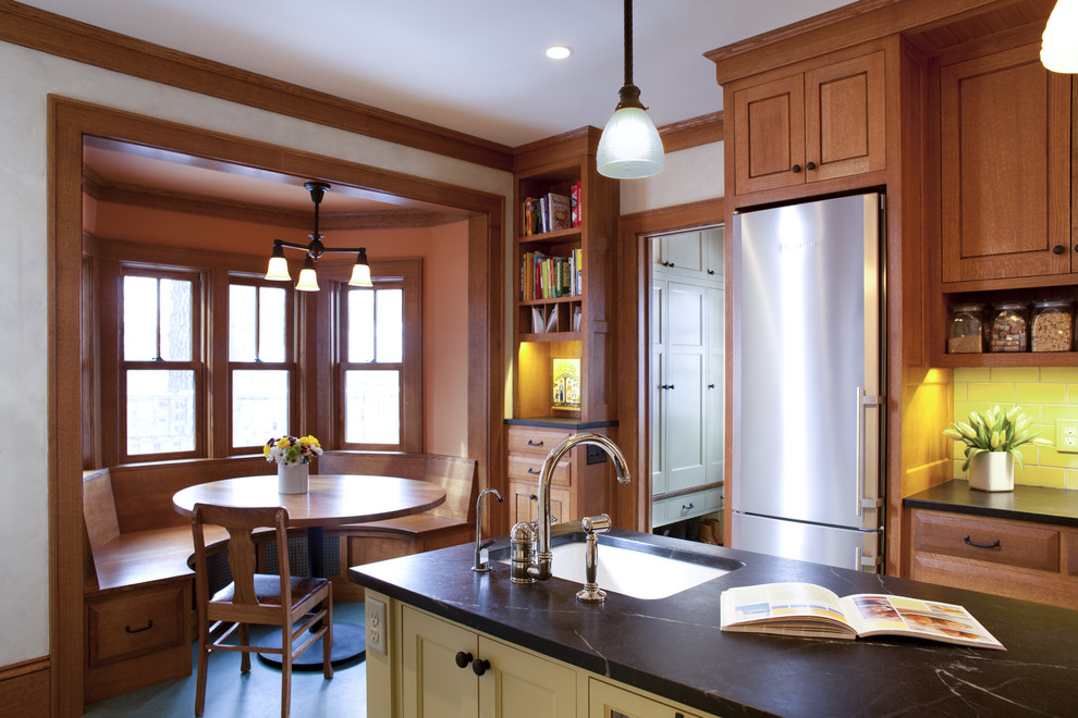 Inspiration for a timeless kitchen remodel in Minneapolis with an undermount sink, recessed-panel cabinets, medium tone wood cabinets, soapstone countertops, yellow backsplash, subway tile backsplash and stainless steel appliances