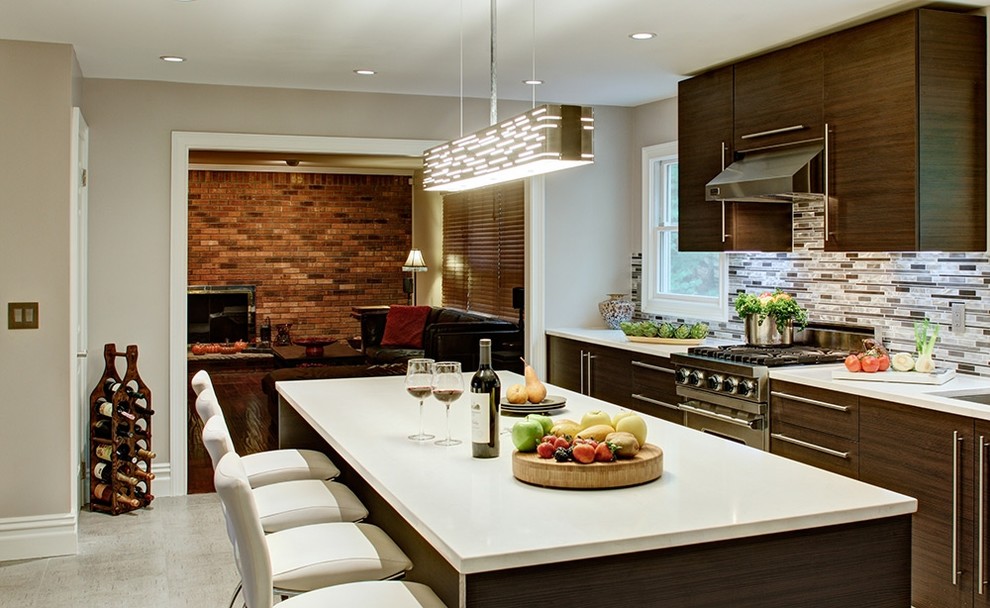 Modern inredning av ett kök och matrum, med en undermonterad diskho, släta luckor, skåp i mörkt trä, flerfärgad stänkskydd, stänkskydd i stickkakel och en köksö