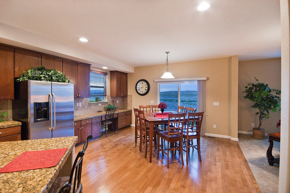 Eat-in kitchen - traditional u-shaped eat-in kitchen idea in Denver with a double-bowl sink, recessed-panel cabinets, medium tone wood cabinets, granite countertops, beige backsplash, ceramic backsplash and stainless steel appliances