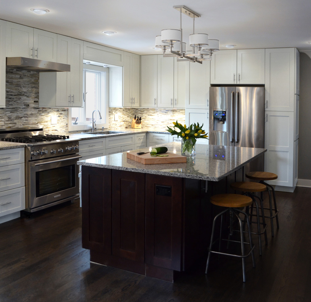Large transitional l-shaped dark wood floor and brown floor eat-in kitchen photo in Chicago with an integrated sink, shaker cabinets, white cabinets, granite countertops, gray backsplash, matchstick tile backsplash, stainless steel appliances and an island