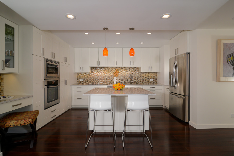 This is an example of a medium sized contemporary u-shaped open plan kitchen in Sacramento with a submerged sink, recessed-panel cabinets, white cabinets, beige splashback, stainless steel appliances, dark hardwood flooring and an island.