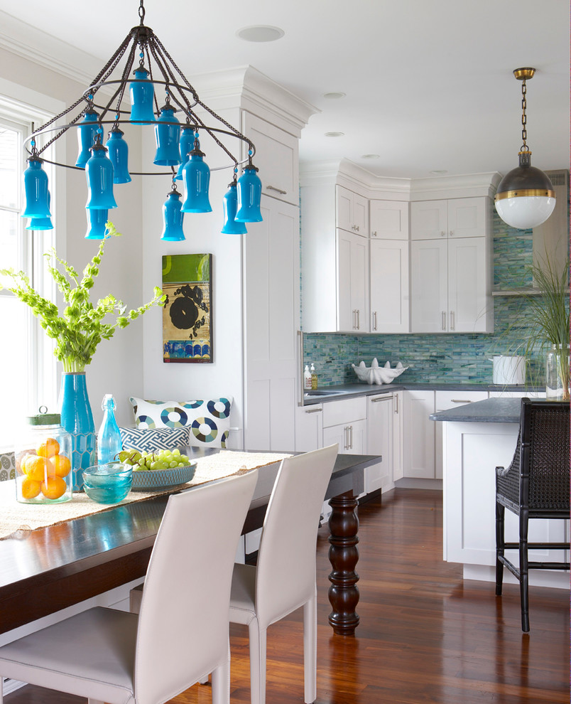 Example of a beach style u-shaped medium tone wood floor eat-in kitchen design in Boston with shaker cabinets, white cabinets, blue backsplash and an island