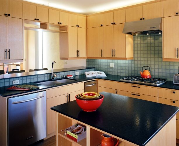 Enclosed kitchen - mid-sized 1960s l-shaped enclosed kitchen idea in Seattle with a double-bowl sink, flat-panel cabinets, beige cabinets, quartz countertops, green backsplash, stainless steel appliances, an island and black countertops