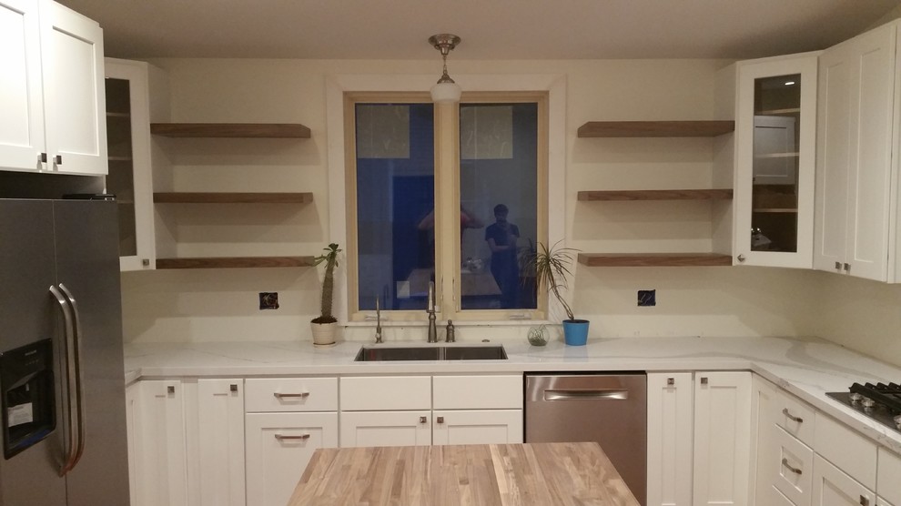 Bild på ett stort funkis kök, med en undermonterad diskho, skåp i shakerstil, vita skåp, träbänkskiva, grönt stänkskydd, stänkskydd i keramik, rostfria vitvaror, mellanmörkt trägolv, en köksö och brunt golv