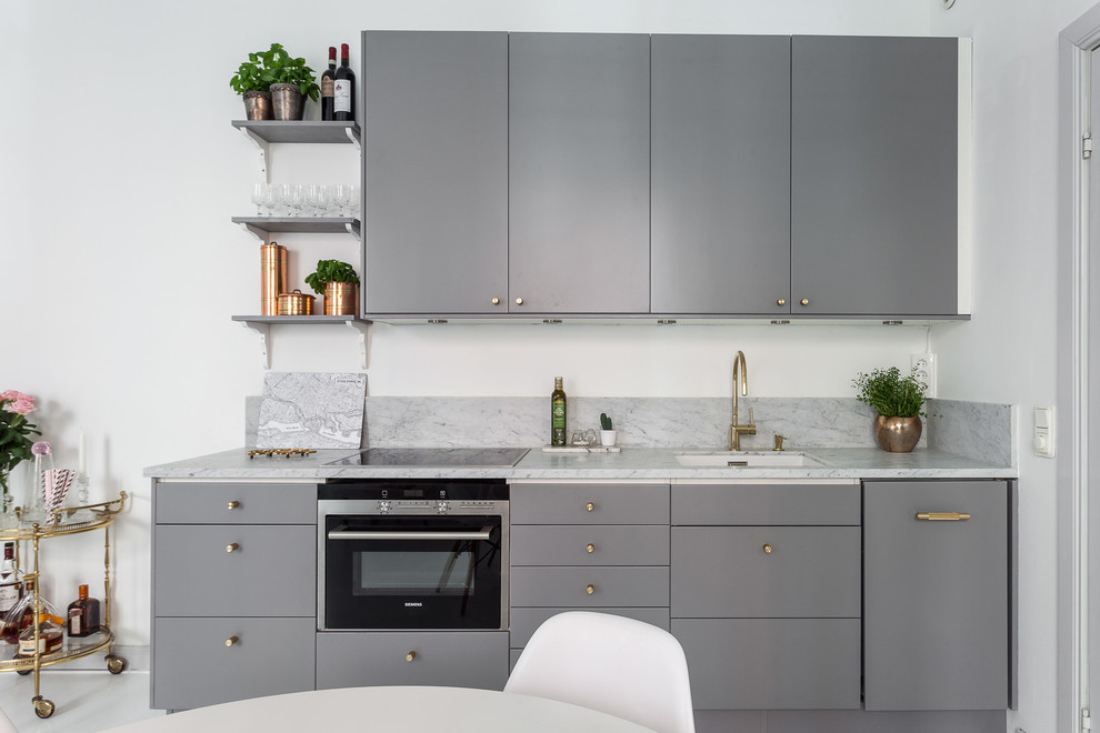Bild på ett mellanstort minimalistiskt kök, med släta luckor och grå skåp