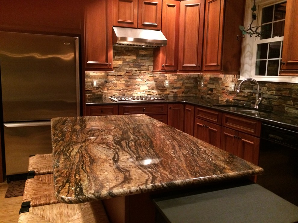 Photo of a medium sized rustic l-shaped kitchen in Baltimore with a double-bowl sink, recessed-panel cabinets, dark wood cabinets, granite worktops, brown splashback, stone tiled splashback, stainless steel appliances, medium hardwood flooring and an island.