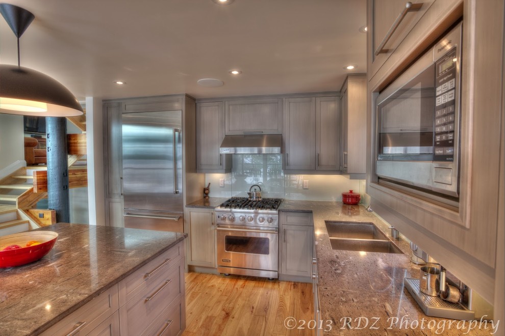 Klassische Wohnküche in L-Form mit Unterbauwaschbecken, Schrankfronten im Shaker-Stil, grauen Schränken, Granit-Arbeitsplatte, Glasrückwand und Küchengeräten aus Edelstahl in Toronto