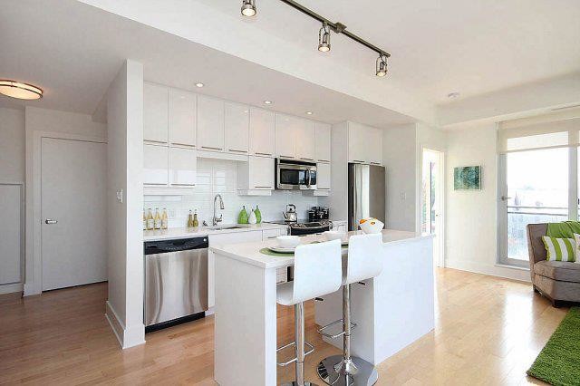 Inspiration for a small contemporary galley light wood floor and beige floor open concept kitchen remodel in Ottawa with an undermount sink, flat-panel cabinets, white cabinets, quartz countertops, white backsplash, subway tile backsplash, stainless steel appliances and an island