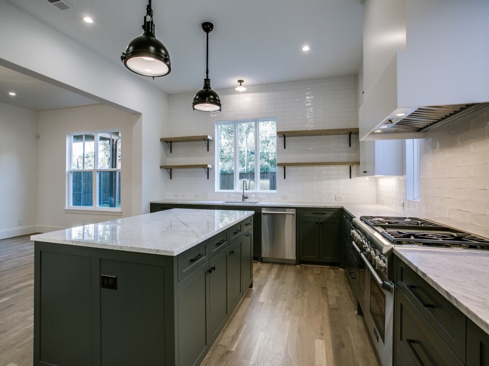 Country u-shaped light wood floor and beige floor kitchen photo in Dallas with an undermount sink, shaker cabinets, green cabinets, marble countertops, white backsplash, ceramic backsplash, stainless steel appliances and an island