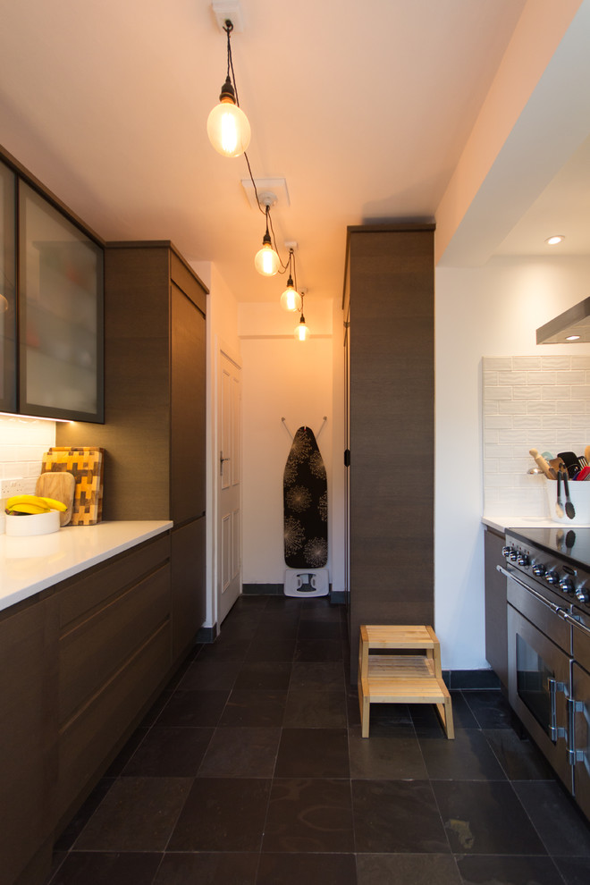 Photo of a small contemporary u-shaped enclosed kitchen in London with an integrated sink, glass-front cabinets, brown cabinets, quartz worktops, white splashback, ceramic splashback, stainless steel appliances, slate flooring and no island.