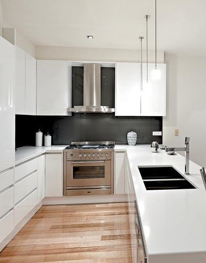 Large minimalist u-shaped light wood floor open concept kitchen photo in Melbourne with an undermount sink, glass-front cabinets, white cabinets, gray backsplash, glass tile backsplash and stainless steel appliances