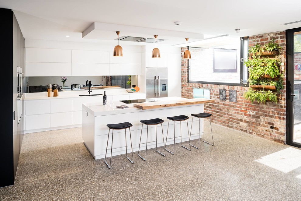 Große Moderne Küche mit flächenbündigen Schrankfronten, weißen Schränken, Rückwand aus Spiegelfliesen, Kücheninsel, grauem Boden und weißer Arbeitsplatte in Melbourne