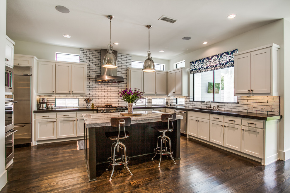 Exempel på ett klassiskt kök, med en enkel diskho, luckor med upphöjd panel, vita skåp, marmorbänkskiva, vitt stänkskydd, stänkskydd i cementkakel, rostfria vitvaror, mörkt trägolv, en köksö och brunt golv