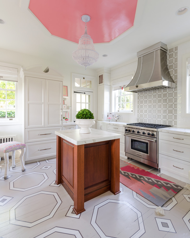 Bild på ett vintage kök, med luckor med infälld panel, vita skåp, flerfärgad stänkskydd, rostfria vitvaror, målat trägolv och en köksö