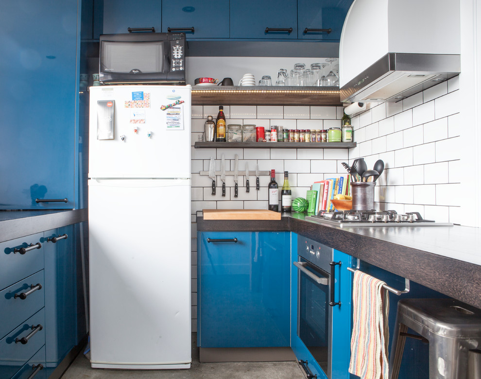 Geschlossene Moderne Küche mit offenen Schränken, weißen Elektrogeräten, Arbeitsplatte aus Holz, Küchenrückwand in Weiß, Rückwand aus Metrofliesen und blauen Schränken in Melbourne