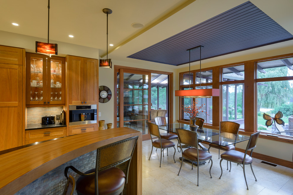 オタワにあるサンタフェスタイルのおしゃれなキッチン (ダブルシンク、シェーカースタイル扉のキャビネット、中間色木目調キャビネット、珪岩カウンター、茶色いキッチンパネル、ベージュの床) の写真