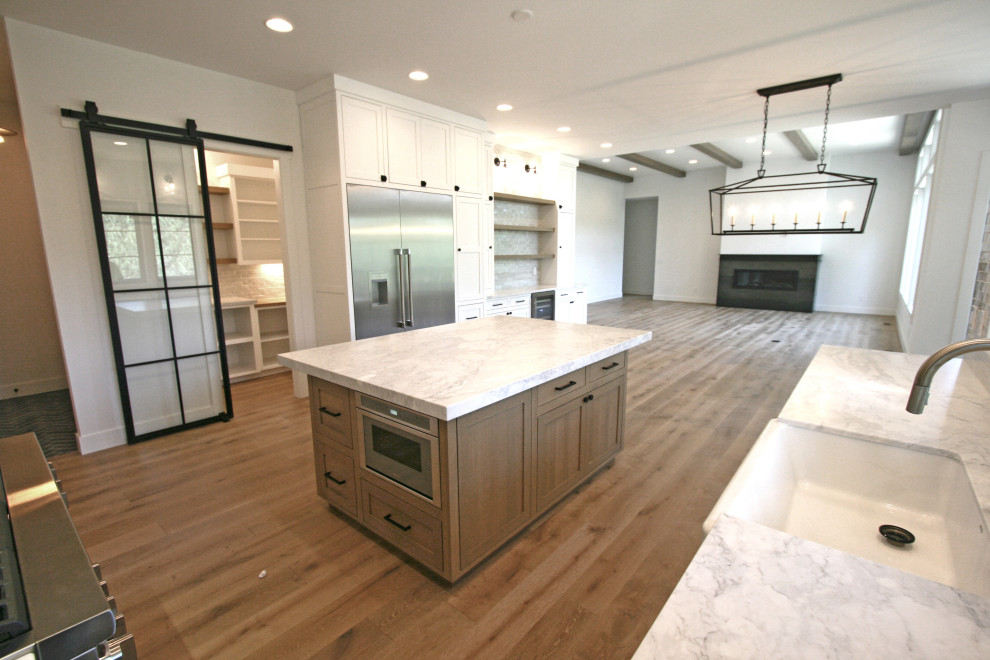 Exempel på ett stort klassiskt grå grått kök, med en rustik diskho, luckor med infälld panel, vita skåp, marmorbänkskiva, grått stänkskydd, stänkskydd i terrakottakakel, rostfria vitvaror, mellanmörkt trägolv, en köksö och beiget golv
