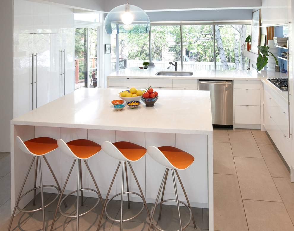 Modern l-shaped kitchen in Toronto with flat-panel cabinets, white cabinets, engineered stone countertops, blue splashback, glass sheet splashback, stainless steel appliances and white worktops.