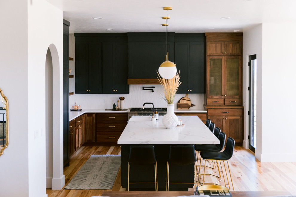 Inspiration for a large rustic l-shaped open plan kitchen in Boise with shaker cabinets, dark wood cabinets, engineered stone countertops, ceramic splashback, an island and white worktops.