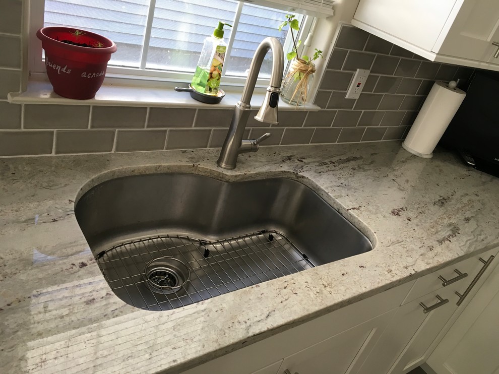 Mid-sized transitional u-shaped cement tile floor and gray floor kitchen photo in New York with an undermount sink, shaker cabinets, white cabinets, granite countertops, gray backsplash, subway tile backsplash, stainless steel appliances, no island and multicolored countertops