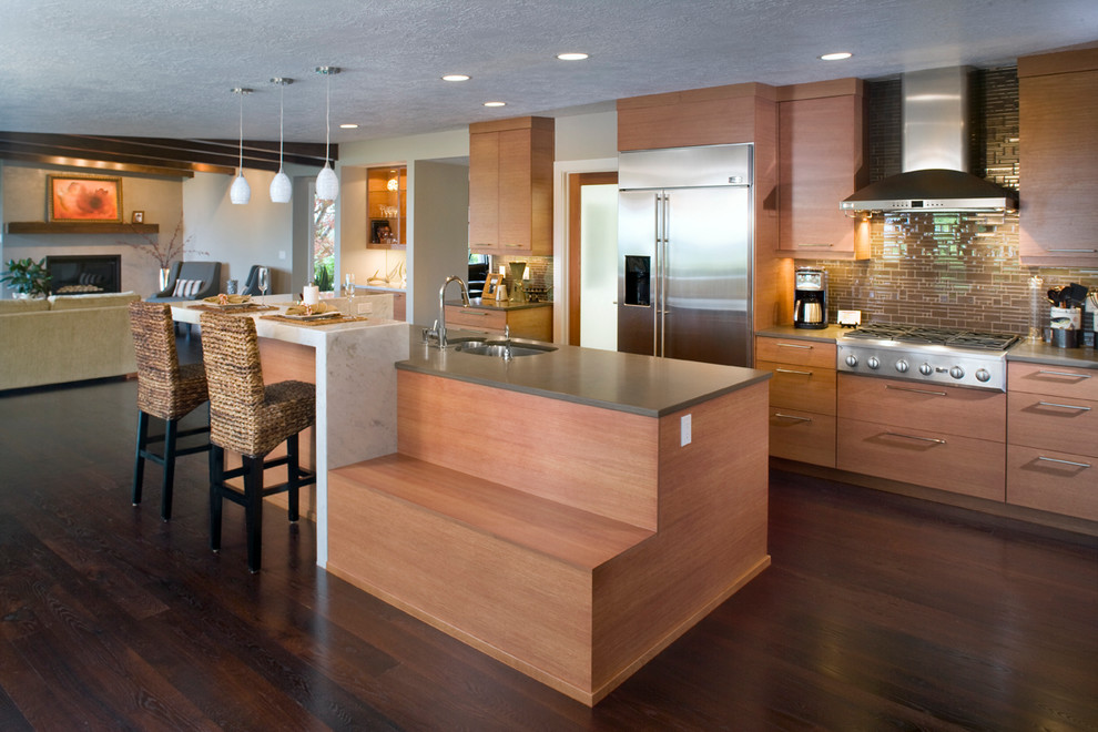 Inspiration for a contemporary open concept kitchen remodel in Boise with a double-bowl sink, flat-panel cabinets, medium tone wood cabinets, brown backsplash and stainless steel appliances
