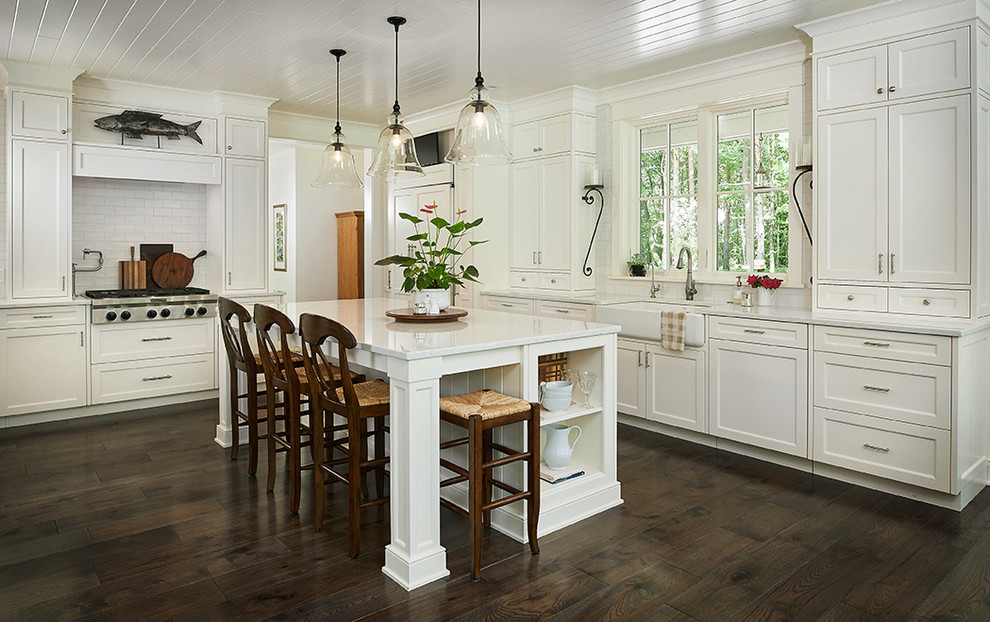 Example of a trendy l-shaped dark wood floor and brown floor kitchen design in Grand Rapids with a farmhouse sink, white cabinets, an island, quartz countertops and yellow backsplash