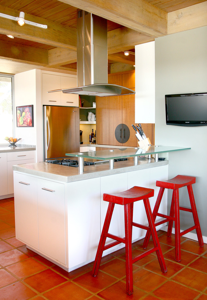 Idéer för att renovera ett mellanstort funkis kök, med en dubbel diskho, släta luckor, vita skåp, bänkskiva i betong, grönt stänkskydd, glaspanel som stänkskydd, rostfria vitvaror, klinkergolv i terrakotta och en halv köksö