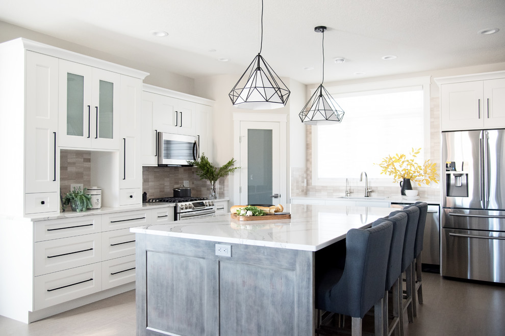 Photo of a medium sized traditional grey and white kitchen in Other with a submerged sink, shaker cabinets, white cabinets, quartz worktops, beige splashback, limestone splashback, stainless steel appliances, cork flooring, an island and beige floors.