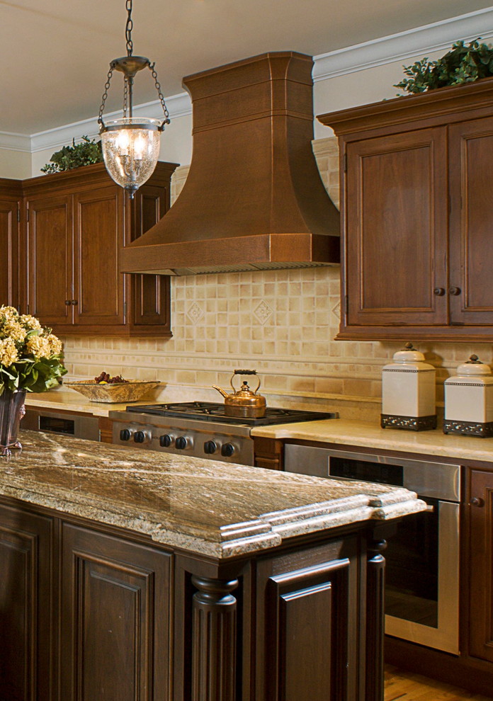 Example of a classic kitchen design in New York with beige backsplash, stainless steel appliances, recessed-panel cabinets, brown cabinets and an island
