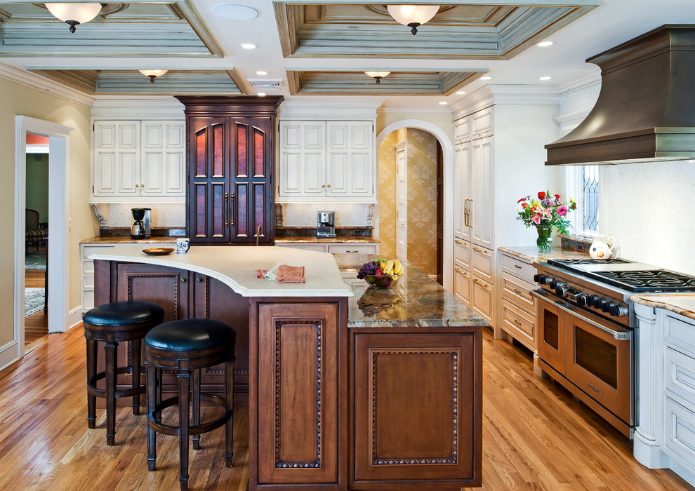 Large traditional l-shaped kitchen/diner in New York with beaded cabinets, white cabinets, white splashback, stainless steel appliances, light hardwood flooring and an island.