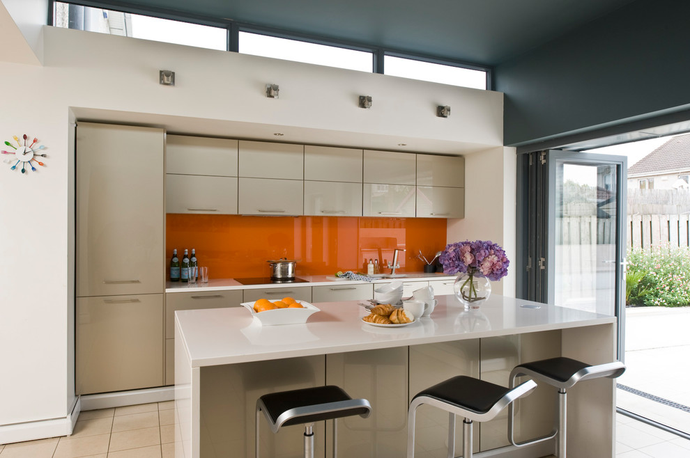 На фото: прямая кухня среднего размера в современном стиле с бежевыми фасадами, оранжевым фартуком и островом