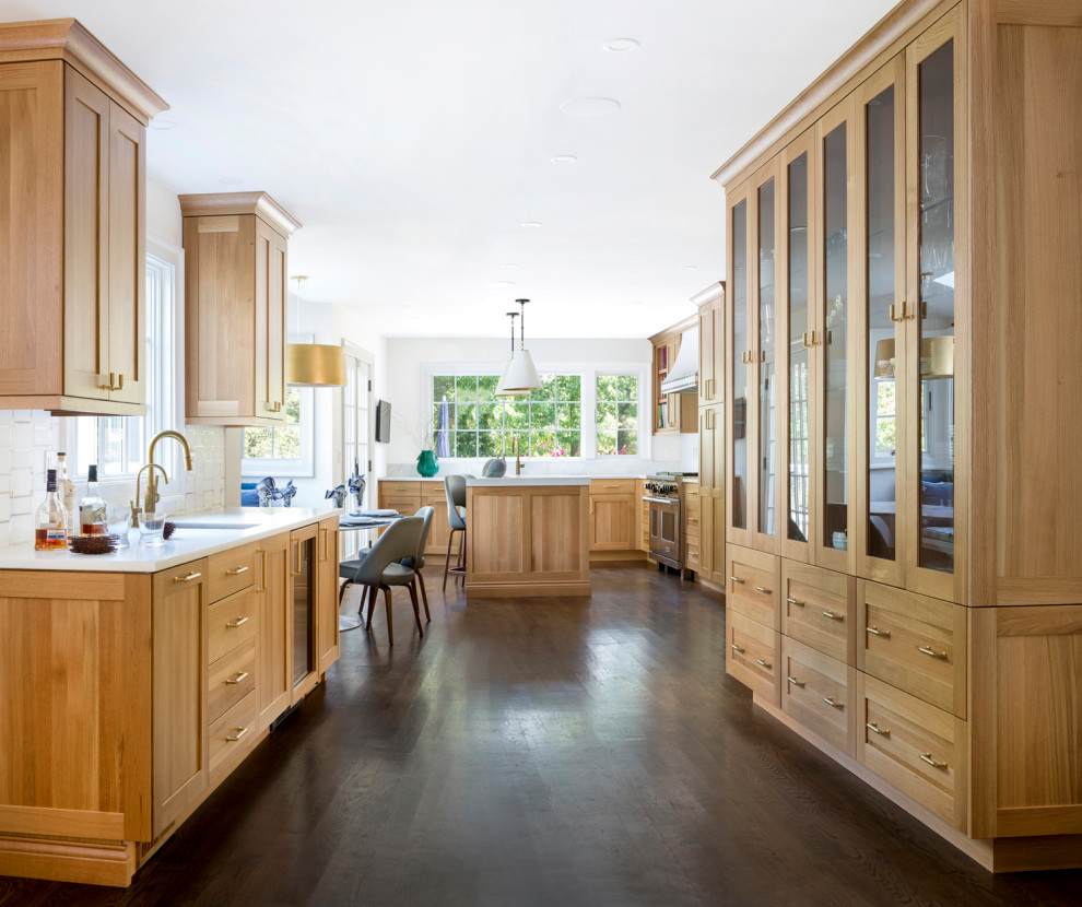 Example of a large transitional l-shaped medium tone wood floor eat-in kitchen design in Philadelphia with an undermount sink, shaker cabinets, light wood cabinets, quartz countertops, white backsplash, porcelain backsplash, paneled appliances, an island and white countertops
