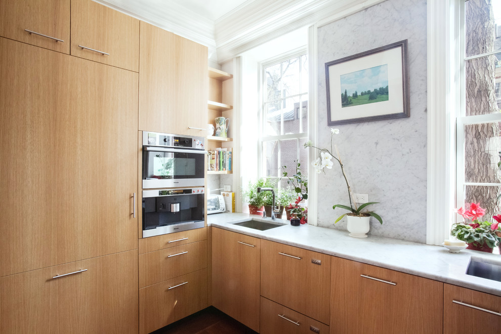 Idéer för ett modernt kök, med en nedsänkt diskho, släta luckor, skåp i ljust trä, marmorbänkskiva och mörkt trägolv