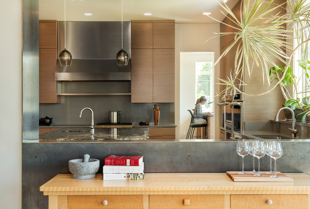 Foto di un cucina con isola centrale minimal di medie dimensioni con lavello sottopiano, ante lisce e elettrodomestici in acciaio inossidabile