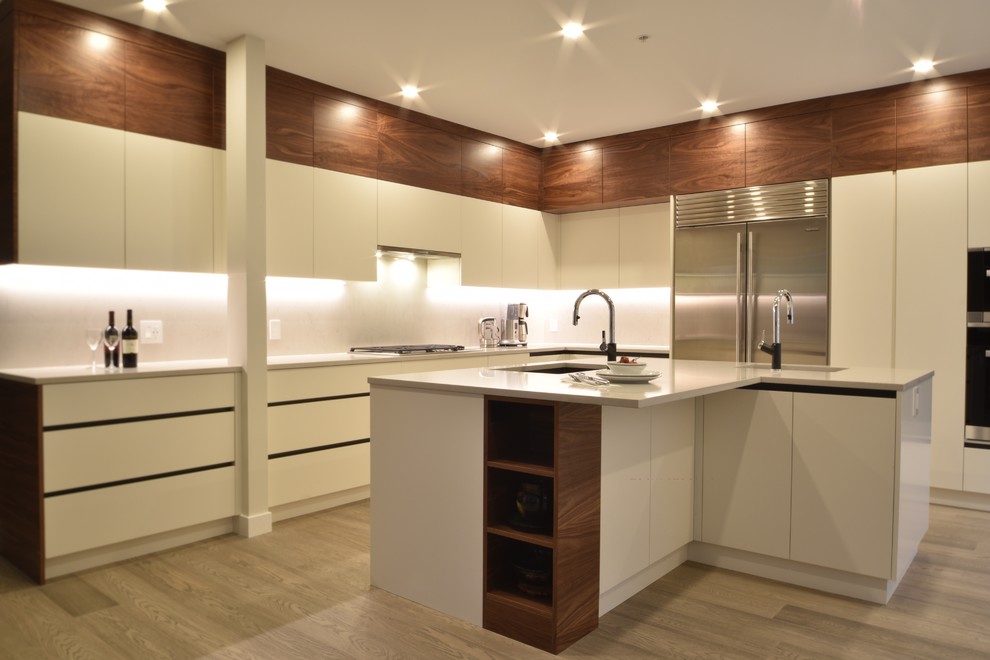 Design ideas for a large contemporary l-shaped kitchen in Vancouver with flat-panel cabinets, white cabinets, engineered stone countertops, stainless steel appliances and light hardwood flooring.