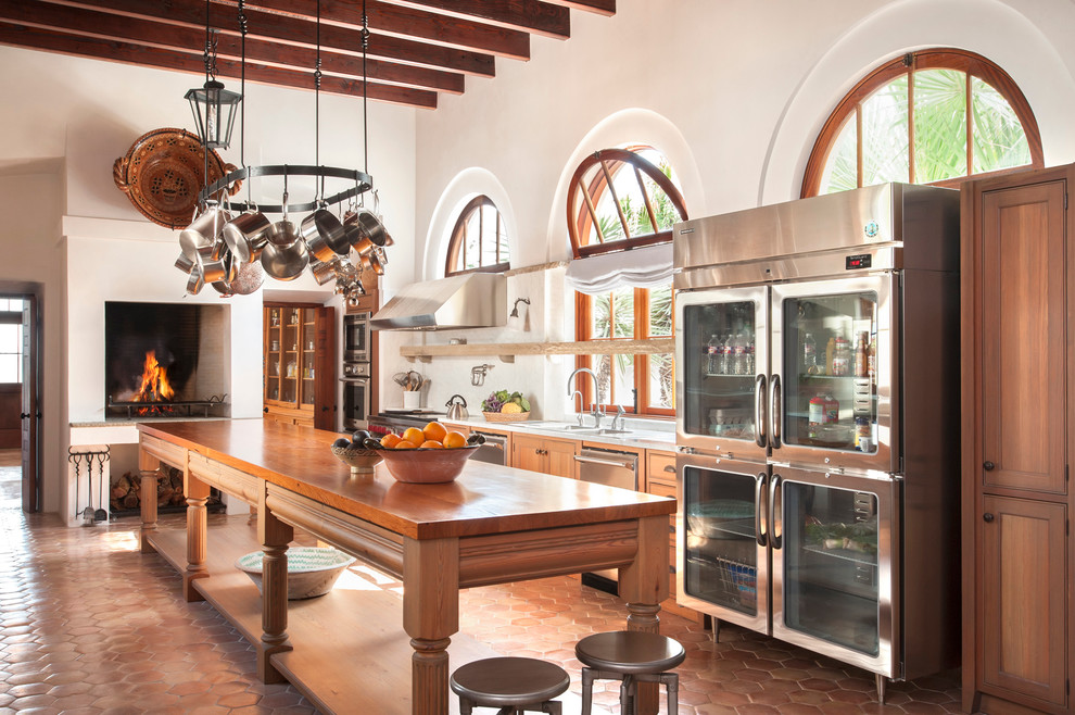 Offene, Zweizeilige, Geräumige Mediterrane Küche mit Küchengeräten aus Edelstahl, Terrakottaboden und Kücheninsel in Austin