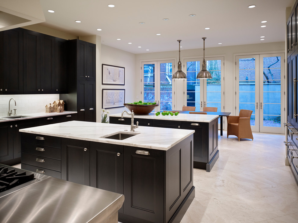 Large transitional limestone floor and white floor eat-in kitchen photo in Philadelphia with an undermount sink, recessed-panel cabinets, dark wood cabinets, marble countertops, white backsplash, ceramic backsplash, paneled appliances and two islands