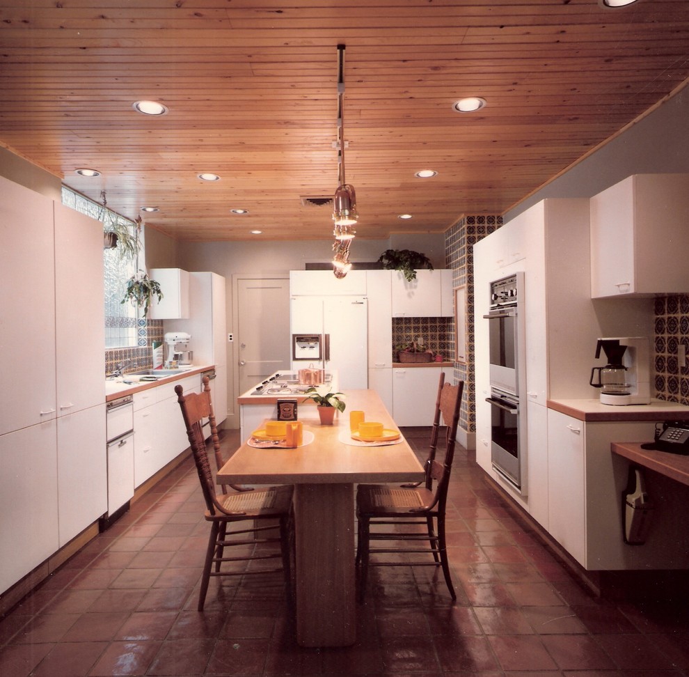 Immagine di una cucina moderna con lavello a tripla vasca, ante lisce, ante gialle, paraspruzzi multicolore, paraspruzzi con piastrelle in ceramica e elettrodomestici da incasso