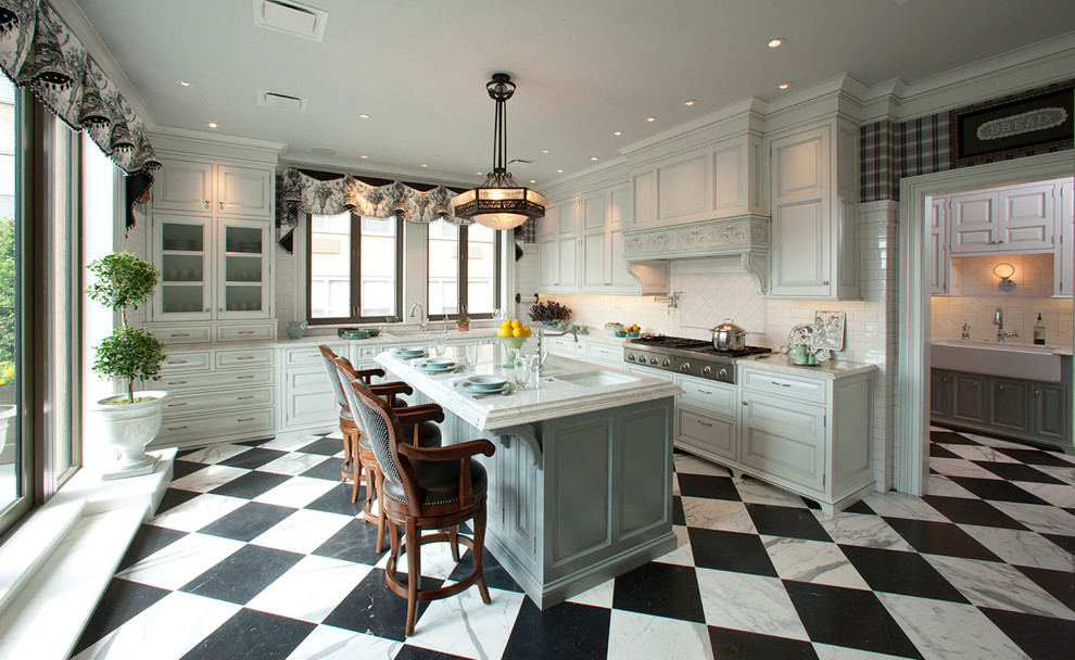 Inredning av ett klassiskt kök, med luckor med upphöjd panel, vita skåp, vitt stänkskydd, stänkskydd i tunnelbanekakel, rostfria vitvaror och flerfärgat golv